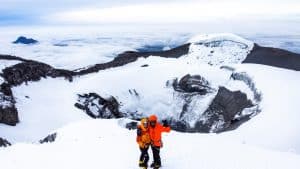 Two Mountaineers at the summit of Cotopaxi. Mountaineering in Ecuador can take you to epic summits like this